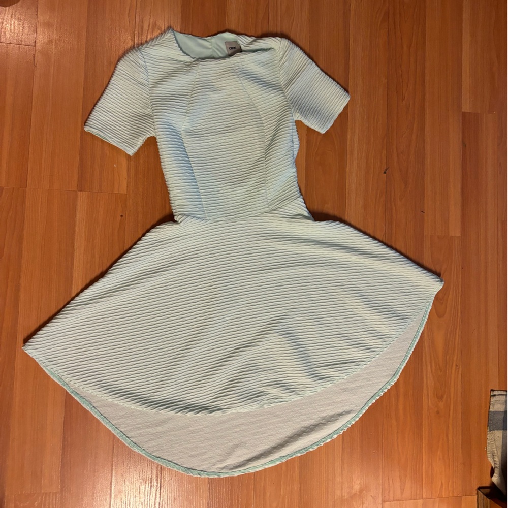 Mint textured hi-lo dress with cut out back and short sleeves.